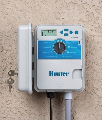 Irrigation controller and pipework installed against an exterior wall